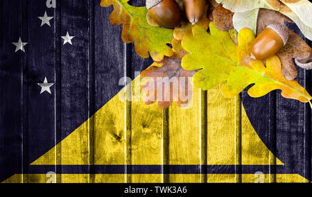 Tokelau Flag auf Herbst Holz- Hintergrund mit Blättern und guter Platz für Ihren Text. Stockfoto