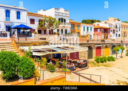 CALELLA DE PALAFRUGELL, SPANIEN - Jul 6, 2019: Restaurant auf canadell Strand mit bunten Häusern in backgrounf in Calella de Palafrugell, Costa Stockfoto