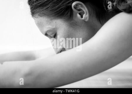 Close-up Seite Blick auf eine junge Frau auf einem sitzend/nach vorne beugen oder Schlafen Swan Asana oder Yoga dar. Stockfoto