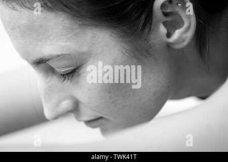 Close-up Seite Blick auf eine junge Frau auf einem sitzend/nach vorne beugen oder Schlafen Swan Asana oder Yoga dar. Stockfoto