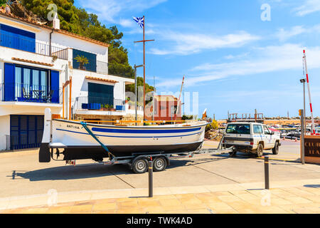 LLAFRANC, SPANIEN - Jul 6, 2019: Auto Transport Fischerboot auf einen Anhänger geladen in Llafranc Dorf Marina, Costa Brava, Spanien. Stockfoto