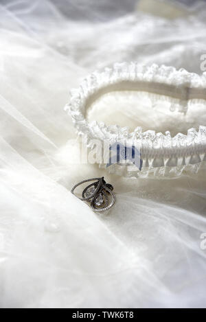 Ear Ring und Strumpfband setup shot auf der Oberseite der Schleier der Braut fertig Stockfoto