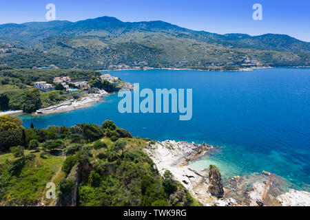 Luftaufnahme von Kassiopi Strand, schöne Bucht und das tiefblaue Meer mit Bergen im Hintergrund Stockfoto