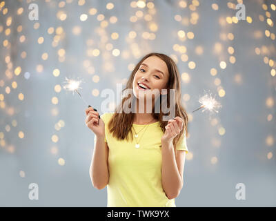 Happy teenage Mädchen mit zwei Wunderkerzen über Leds Stockfoto