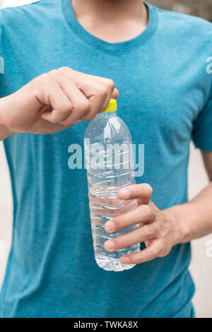 Hand öffnende Deckel Flasche Trinkwasser, nach der Übung abgeschlossen ist Stockfoto