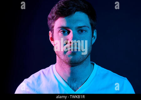 Porträt des Menschen über die neonröhren in dunklen Zimmer Stockfoto