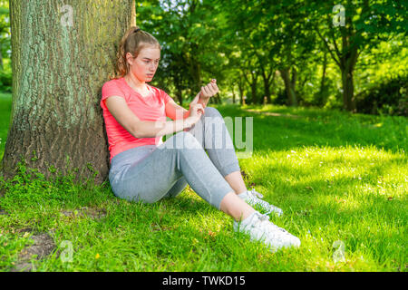 Eine junge Frau macht Pause beim Sport und Maßnahmen ihren Puls. Stockfoto