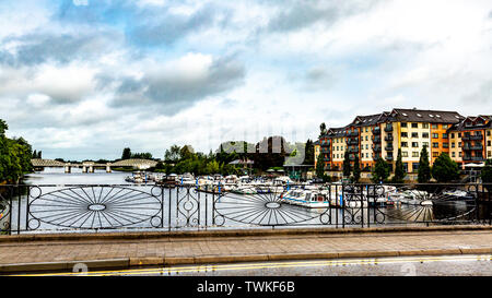 Blick auf den Fluss Shannon durch den Zaun der Schmied, Boote am Dock mit der S-Bahn Brücke im Hintergrund verankert Stockfoto