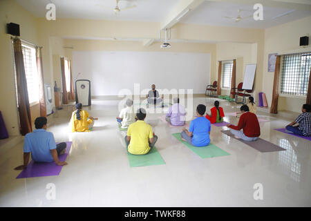 Bangalore, Karnataka, Indien. 13 Dez, 2018. 13 Dez 2018 - Bangalore, Indien. ein Yogalehrer führt eine Klasse auf Yoga-stellungen im Yoga Zentrum in NIMHANS. Nach verschiedenen wissenschaftlichen Tests der NIMHANS Zentrum zu dem Schluss, dass es immense positive heilende Wirkung des Yoga auf den Körper und das Singen von dem Wort 'AUM' hilft der Verstand einen tiefen Zustand der Entspannung erreichen. Credit: Subhash Sharma/ZUMA Draht/Alamy leben Nachrichten Stockfoto