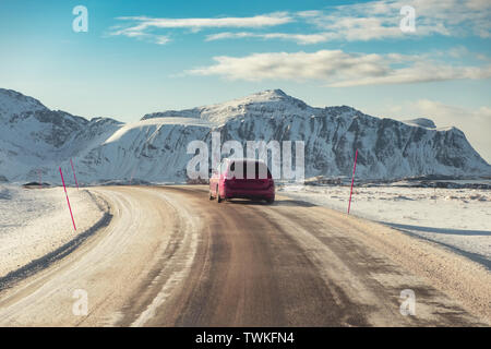 Red SUV Auto auf Landstraße mit Berg im Winter in Norwegen Stockfoto