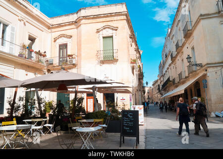 Lecce, Italien, 10.10.2016; zwei Reisende mit dem Gepäck auf ihrer Schulter auf der Straße von Lecce, die schnell gehen und in einem schönen Herbst morgen sprechen. Stockfoto