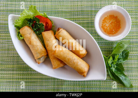 Vietnamesische gebratene Frühlingsrollen mit Soße serviert. Ansicht von oben. Stockfoto