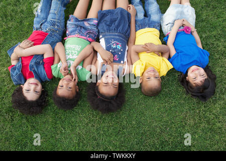 Gruppe von Kindern auf dem Rasen liegend Stockfoto