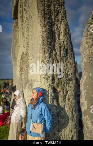 Ein Besucher zu Stonehenge in Wiltshire dauert einen Moment für sich selbst während der Sunrise am alten Denkmal auf der Sommersonnenwende. Bild Datum Freitag Stockfoto