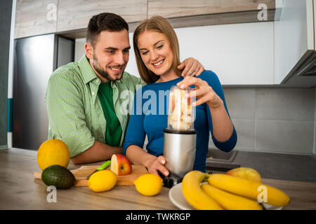 Junges Paar bereitet Saft in Ihre Küche. Stockfoto