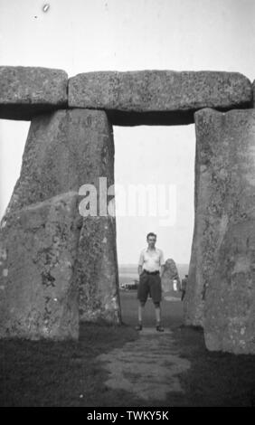 Der Mensch steht zwischen Säulen aus Stein in Stonehenge, Wiltshire, England c 1950 Foto von Tony Henshaw Stockfoto