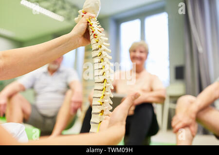 Physiotherapeut erklärt zu den seniors die Ursache für Rückenschmerzen in einer rehab Workshop Stockfoto