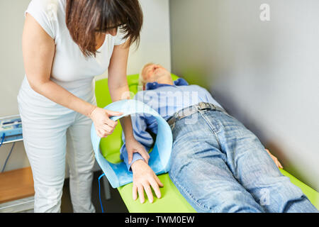 Arzt oder Heilpraktiker behandelt, handgelenk Schmerzen mit Magnetfeldtherapie Stockfoto