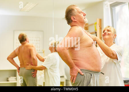 Heilpraktiker behandelt älterer Patienten mit Rückenschmerzen in der lendenwirbelsäule Physiotherapie Stockfoto