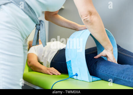 Heilpraktiker behandelt Patienten auf Kniegelenk mit magnetische Therapie zur Schmerzlinderung Stockfoto