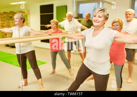 Gruppe von sportlichen Senioren tun Rehabilitation im Ballet bar in der Physiotherapie Stockfoto
