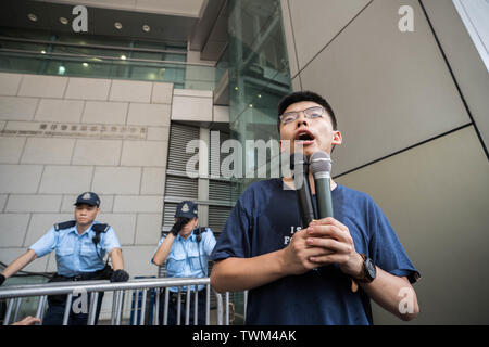 Joshua Wong, Mitbegründer der Demosisto politische Partei spricht mit Demonstranten vor dem Polizeipräsidium während des Protestes. Die Demonstranten hat die Hauptverkehrsstraßen in Hongkong belegt die Regierung die Auslieferung Bill und der Hauptgeschäftsführer von Hong Kong Carrie Lam nach unten von der Macht zu Schritt zum Rücktritt zu verlangen. Stockfoto