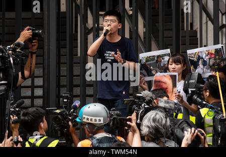 Joshua Wong, Mitbegründer der Demosisto politische Partei, spricht mit der demonstrant auf dem Polizeipräsidium versammelt. Trotz versuchen, den Chief Executive Carrie Lam der Spannungen durch die Zustimmung der umstrittene Auslieferung Rechnung, Studentengruppen und Union auszusetzen zu erleichtern hat der Protest gegen die Regierung von Hongkong weiter. Die Demonstranten forderten den Rücktritt der umstrittenen Auslieferung Rechnung, die Freigabe und nicht-strafrechtliche Verfolgung der Menschen durch die Ursache, Untersuchung, ob exzessive Gewaltanwendung durch die Polizei am 12. Juni verwendet wurden festgenommen, und den Rücktritt von Carri Stockfoto