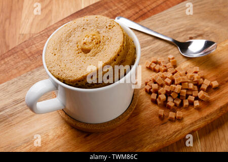 Leckeres fudge Sponge pudding Schuß auf ein Brett mit einer Hand voll Stücke fudge, in eine Schale mit einem Löffel. Stockfoto