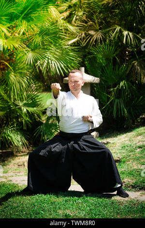 Junge ernster Mann aikido Master in traditioneller Tracht Stockfoto