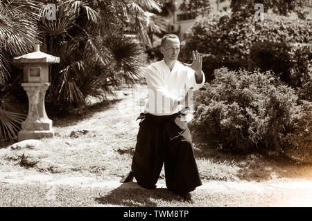 Junge ernster Mann aikido Master in traditioneller Tracht Stockfoto