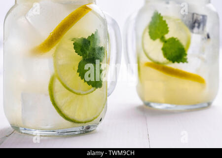 Kalte Limonade mit Eis. Zitrone und Grüne Minze in Mason Jar auf dunklem Hintergrund. Stockfoto