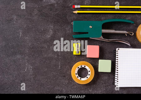 Sortiert von Schulmaterial auf schwarzem Schiefer. Zurück zum Konzept der Schule. Copyspace Stockfoto