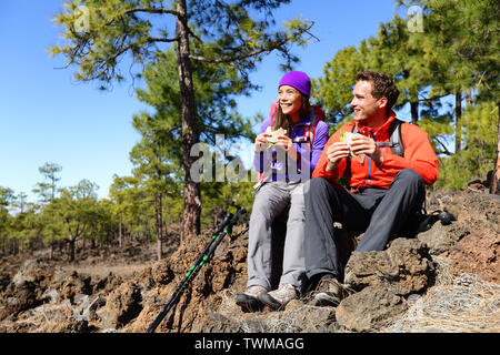 Paar Mittagessen eine Pause wandern genießen Sandwiches. Wanderer, aktiven Lebensstil in Berg Natur. Frau und Mann Wanderer sitzen auf Wanderung auf den Vulkan Teide, Teneriffa, Kanarische Inseln, Spanien. Stockfoto