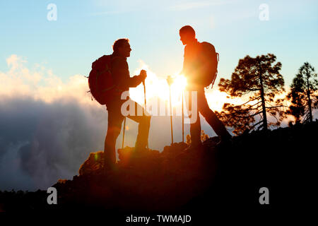 Wandern auf der Suche Sonnenuntergang Blick auf Wanderung während Trek in Berg Natur Landschaft bei Sonnenuntergang. Aktiv gesund Paar, Aktivitäten im Freien. Stockfoto