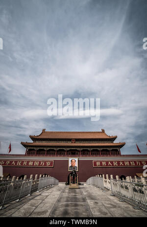 März 27, 2019: Guard steht vor einem riesigen Portrait von Mao Tzedong auf das Himmlische Tor zur Verbotenen Stadt, dem Platz des Himmlischen Friedens, Peking, China, Stockfoto