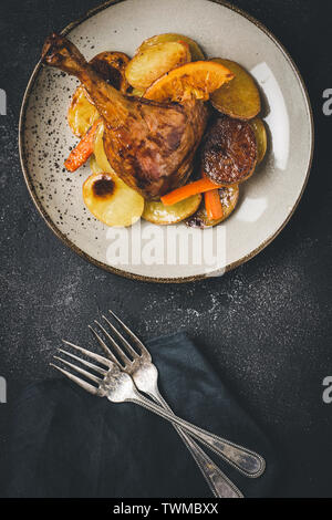 Brathähnchen Bein Gericht mit Kartoffeln, Karotten und Orangen Stockfoto