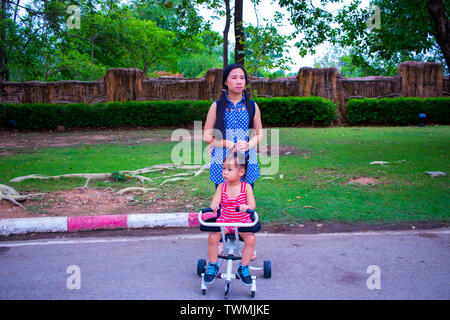 Mutter gehen, während er einen Kinderwagen im Park High resolution Image Gallery. Stockfoto