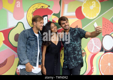 Eine Gruppe von Freunden eine selfie vor einem bunten Wand Stockfoto