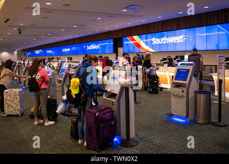 Orlando, Florida. Juni 06, 2019. Frauen mit selbst Maschine im Südwesten Zähler zum Orlando International Airport. Stockfoto