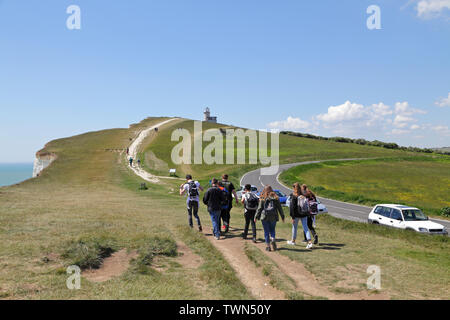 Studenten, die den Klippenpfad zum Belle Tout Lighthouse in Beachy Head, South Downs, Sussex, Großbritannien, hinaufgehen ein Teil des Pfades ist nun ins Meer gefallen Stockfoto