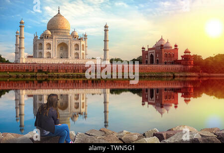 Taj Mahal Agra Sonnenuntergang mit jungen weiblichen Touristen genießen den Blick von mehtab Bagh am Ufer des Flusses Yamuna Stockfoto
