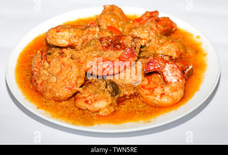 Indische scharfes Essen Garnelen Curry zubereitet mit Kokosnuss als Beilage mit Reis auf weißem Hintergrund serviert. Stockfoto