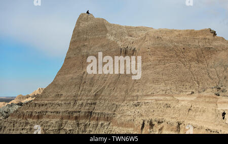 Ein einsamer Mann sitzt auf einem Mesa oder Butte in den Badlands von South Dakota. Stockfoto