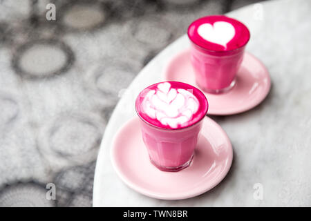 Zwei Gläser rosa Rote Beete Latte mit schönen Latte Art auf Marmor tisch Hintergrund. Trendy gesundes Getränk. Stockfoto