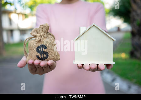 Ein Modell Haus Modell ist auf die Hände des Geschäfts in Asien Mädchen gelegt. Als Hintergrund Geschäftskonzept und Immobilien konzept mit Platz für Sie kopieren Stockfoto