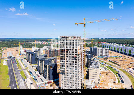 Entwicklung von neuen Wohngegend. Kran und Gebäude Baustelle gegen den blauen Himmel. Luftaufnahme Stockfoto