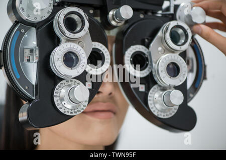 Junge Mädchen an der Rezeption am Patienten Arzt Augenarzt. Diagnose ophthalmologische Geräte. Optische Maschine. Medizin Konzept Stockfoto