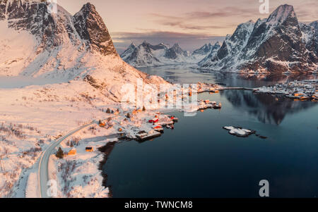 Luftbild des Skandinavischen Dorf an der Küste in Snowy Valley bei Sonnenuntergang. Lofoten Stockfoto