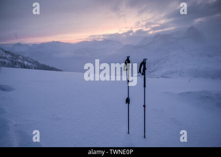 Trekking Polen der Kletterer auf verschneiten Hügel im Blizzard bei Sonnenaufgang Stockfoto