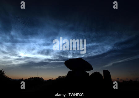 Nacht Landschaft mit Stahl blau noctiliucent Wolken mit der Silhouette eines runden Barrow im Vordergrund. Stockfoto